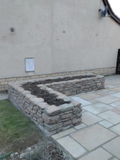Sandstone patio and raised stone flower/planting bed