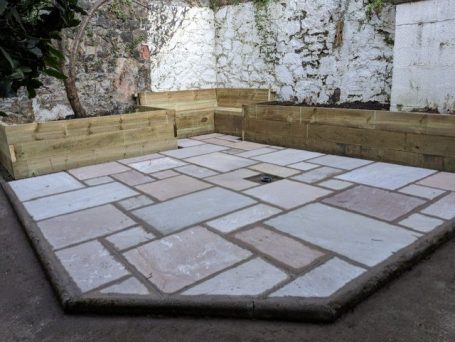 sandstone patio with timber raised bed and seating